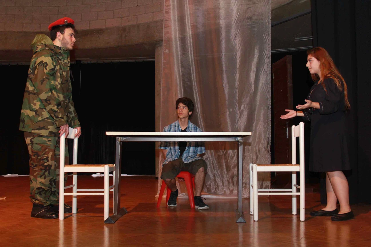 Alex Dahdah, at left in camouflage and a red beret, performing with two other actors in Balle de mémoire. · Balle de Mémoire