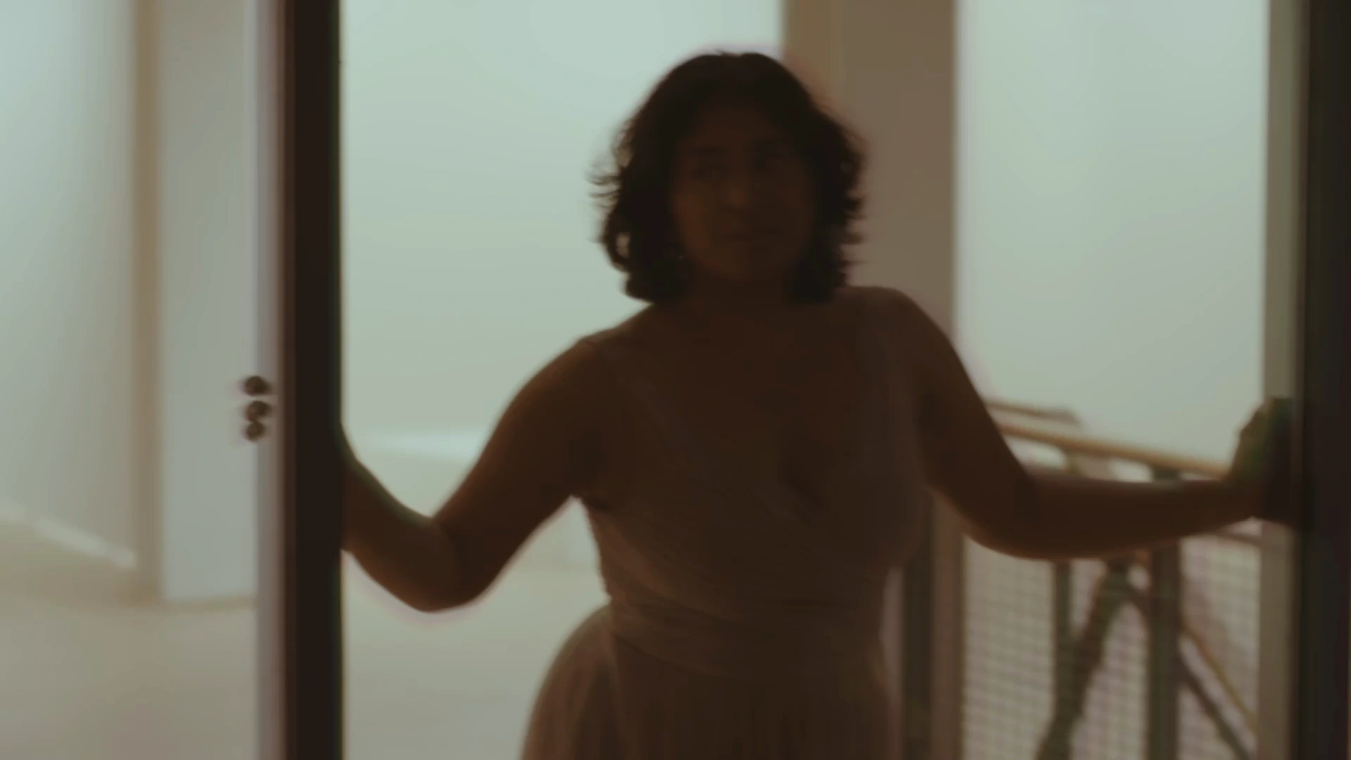 Selected frame from Connected. Trisha Gupta at the doorway.