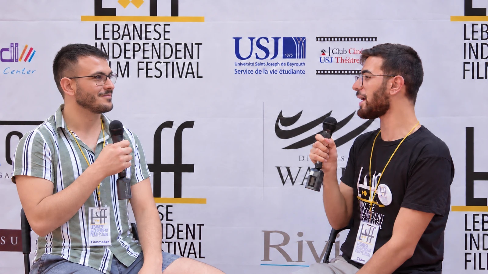 Alex Dahdah listening to the interviewer with a relaxed smile at LIFF 2023, with refined event lighting