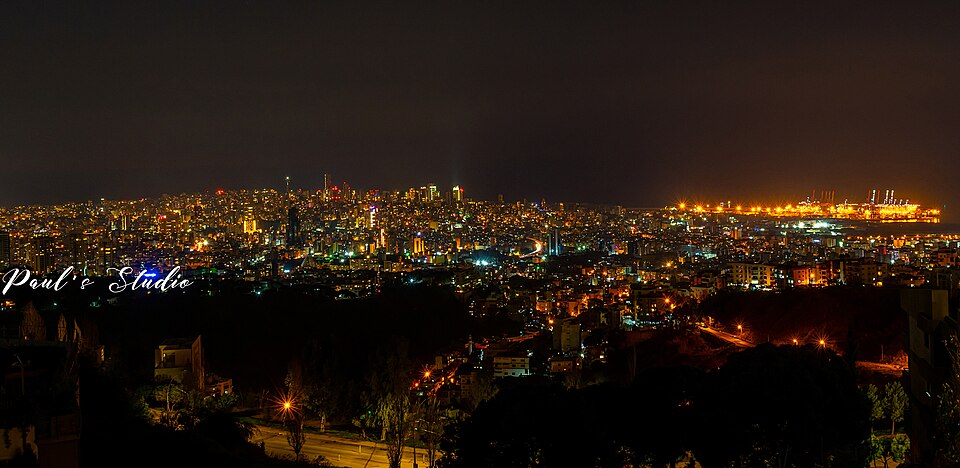 A wide view of Beirut after dark with illuminated buildings and streets.