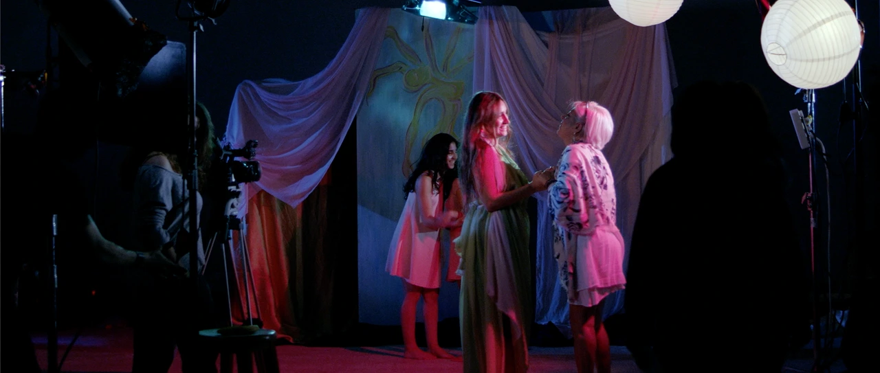 Production view with performers and camera equipment · Reflecting on Scandal